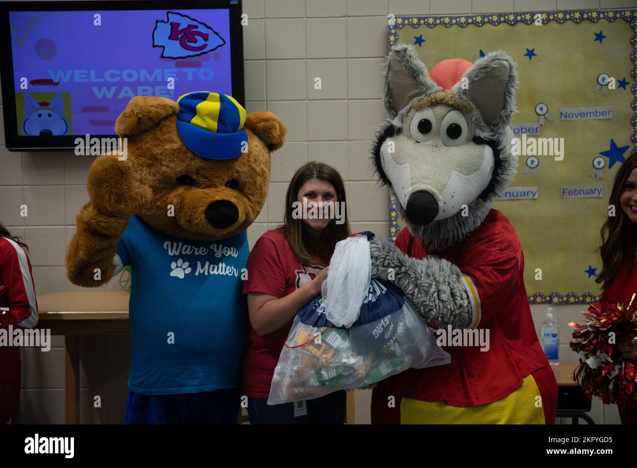 The Ware Elementary School mascot, Warebear, stands with Veronica Wait, the principal of Ware Elementary School, as the Kansas City Chiefs mascot, KC Wolf, donates flag football equipment on Fort Riley, Kansas, Nov. 4, 2022. KC wolf gave away a flag football kit to each of Fort Riley’s elementary and middle schools during his first ever visit to Fort Riley. Stock Photo