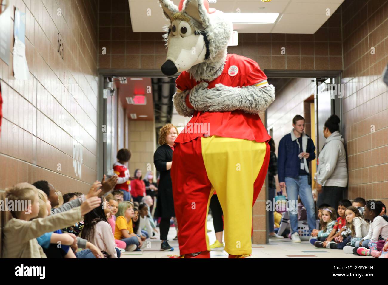 Kansas City Chiefs Mascot KC Wolf, meets with students and staff at Fort Riley Elementary school during a community engagement visit to Fort Riley, Kansas, Nov. 4, 2022. During this first-time visit, representatives from the team visited multiple schools on the installation and gave out flag football kits as part of the growing partnership with the 1st Infantry Division and the Chiefs. Stock Photo