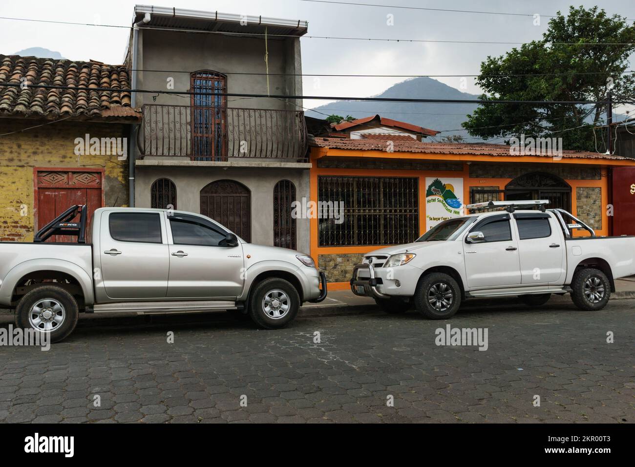 Two white HiLuxes front bumpers facing each other.  The HiLux is one of the most popular trucks in Nicaragua, and the police use blue and white ones. Stock Photo