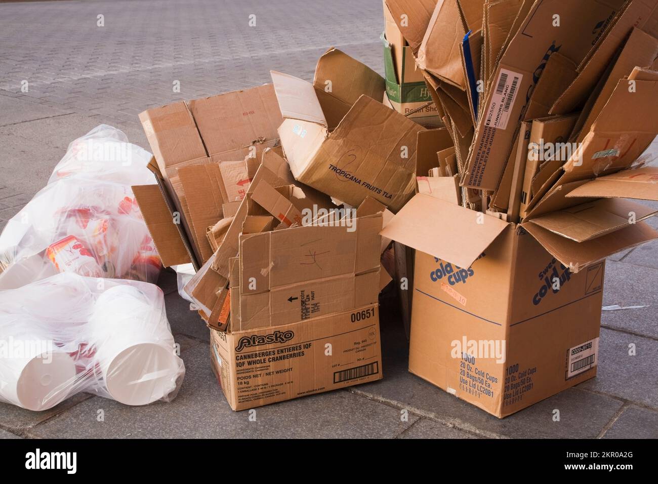 Cardboard boxes and plastic bags on city sidewalk ready to be picked up for recycling, Old