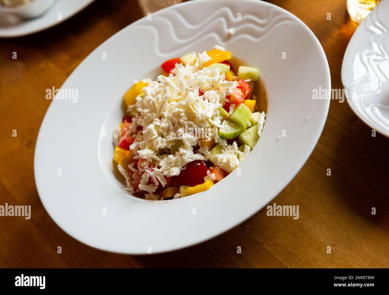 Dish of Balkan cuisine Shopska salad with cucumbers, tomatoes, bell