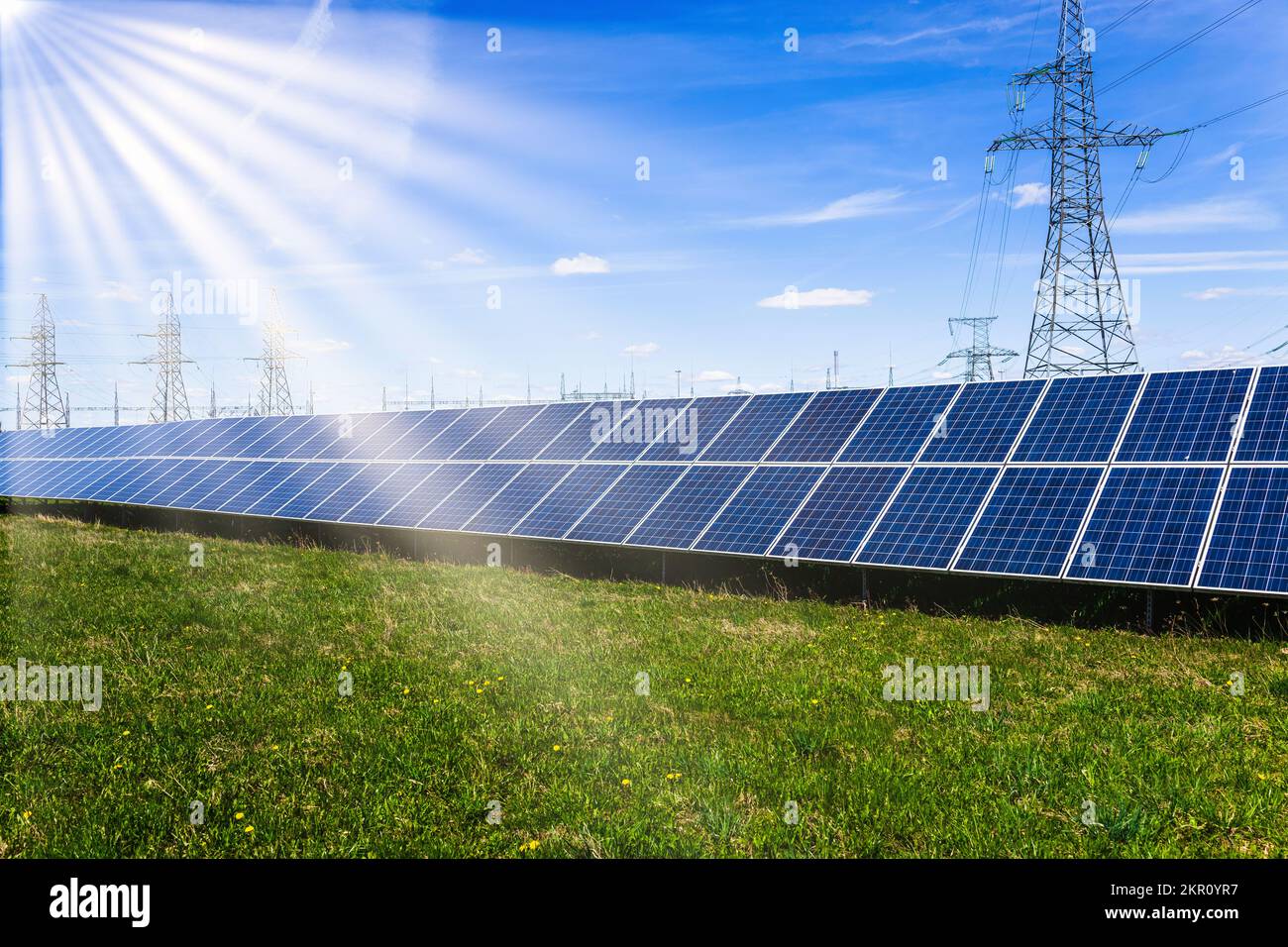 Solar panels, high voltage electricity towers, and sun rays Stock Photo