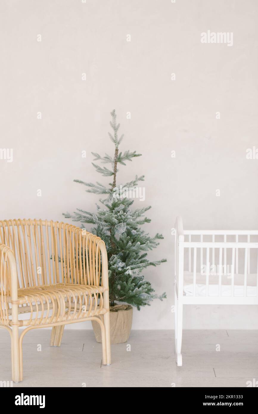 Small christmas tree next to baby rocking chair and baby bassine Stock ...