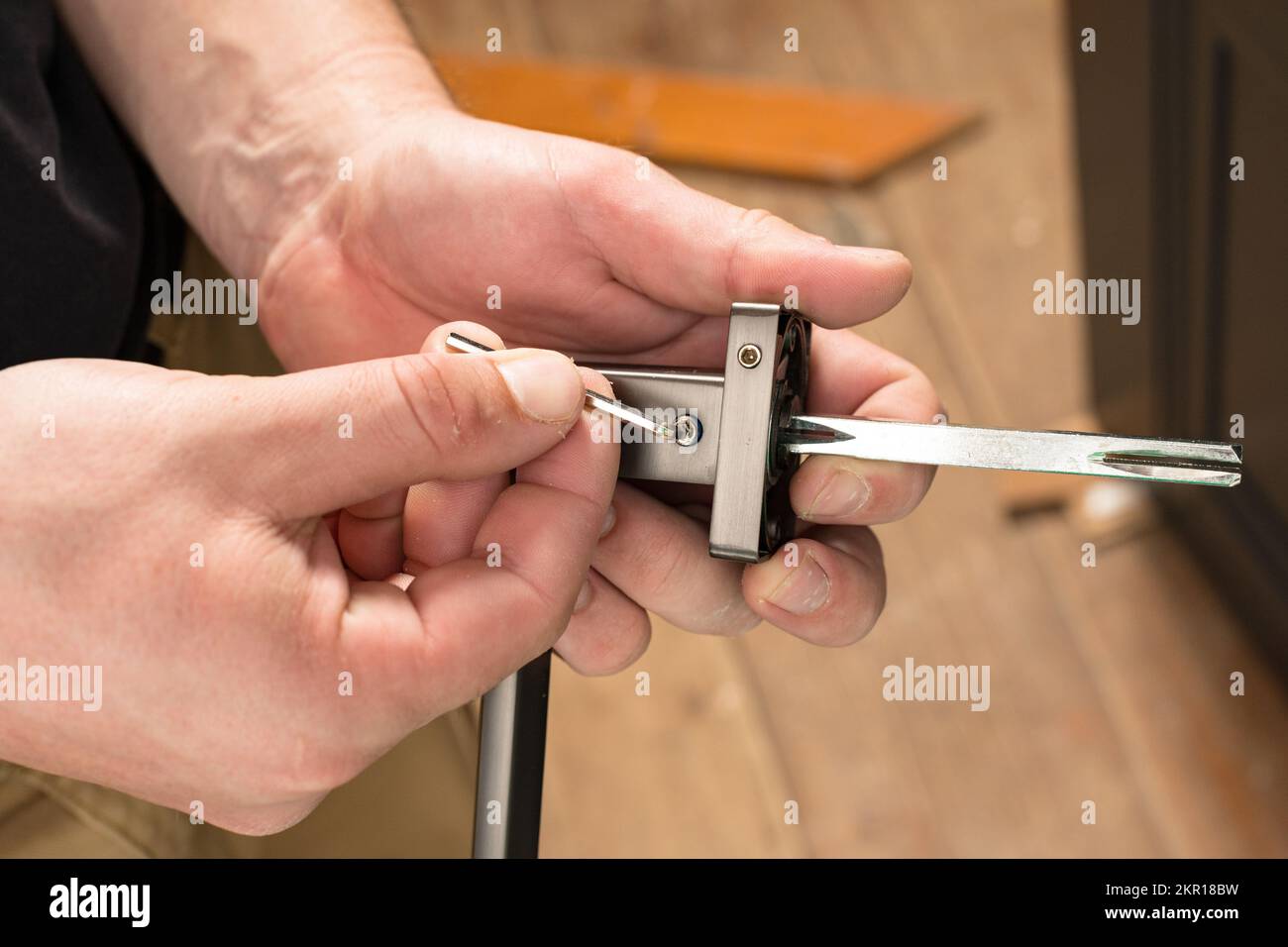 Handyman holding a doorknob and hex key, doorknob installation, metal