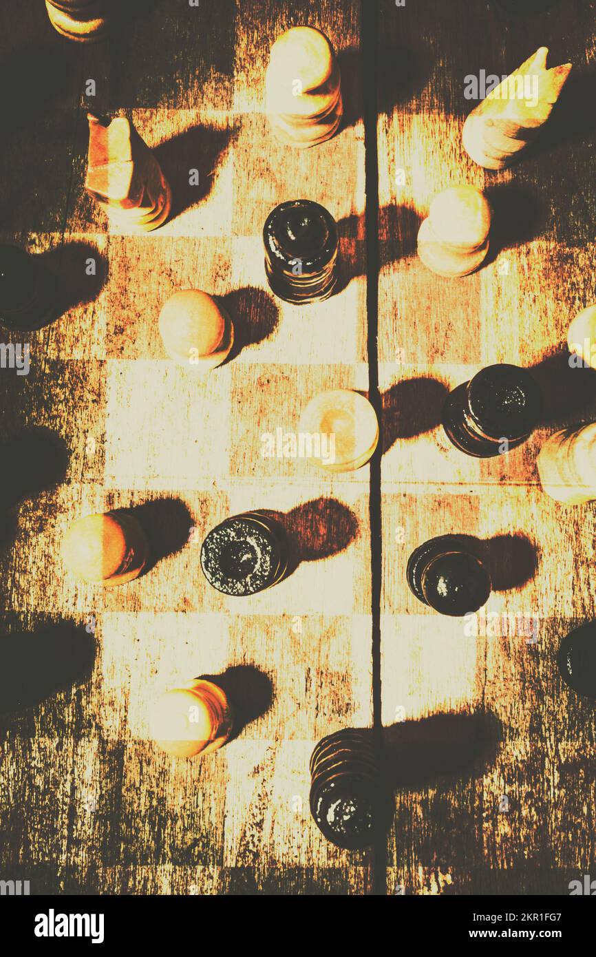 Blurring the rules of play, vintage chess pieces walk a fine line between opposition and allied. 50 shades of good and evil Stock Photo