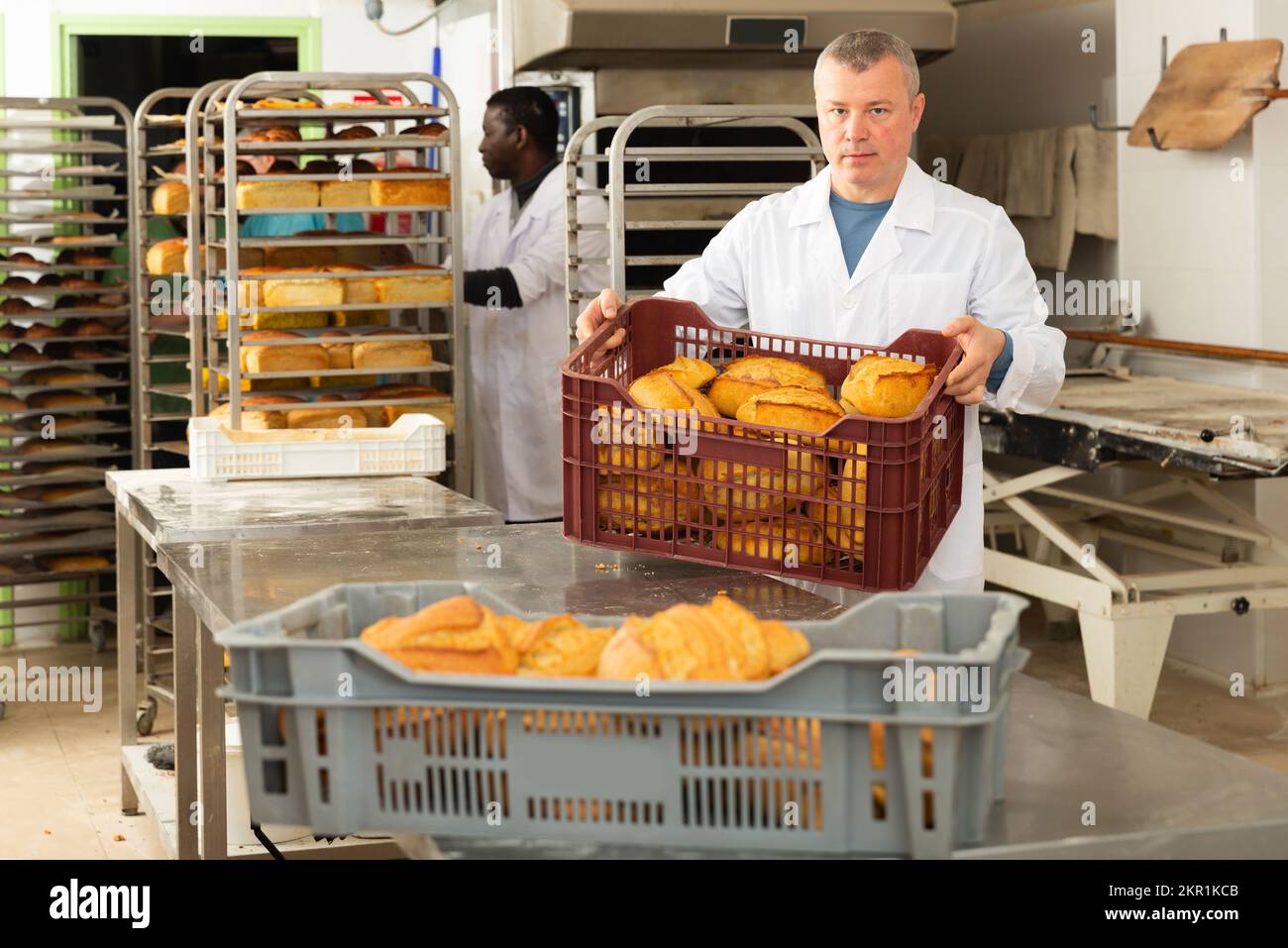 Two bakers arranging baked bread in bakery Stock Photo