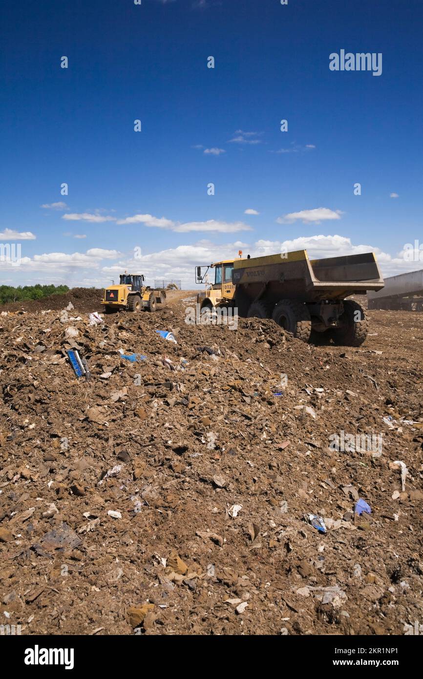 Loader and Volvo A250 dump truck on mound of debris at waste management