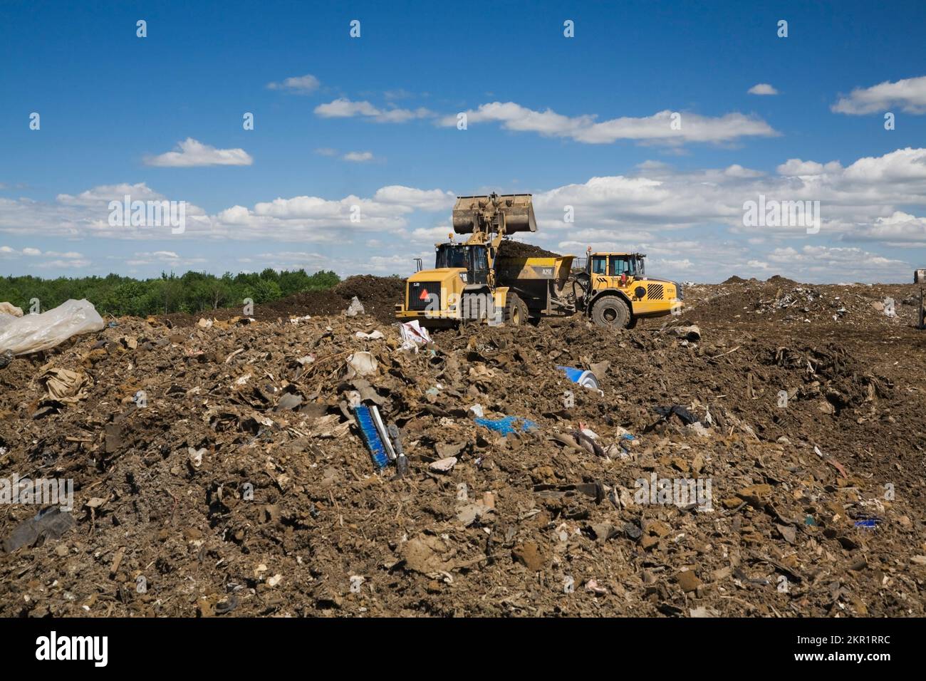 Loader and Volvo A250 dump truck on mound of debris at waste management
