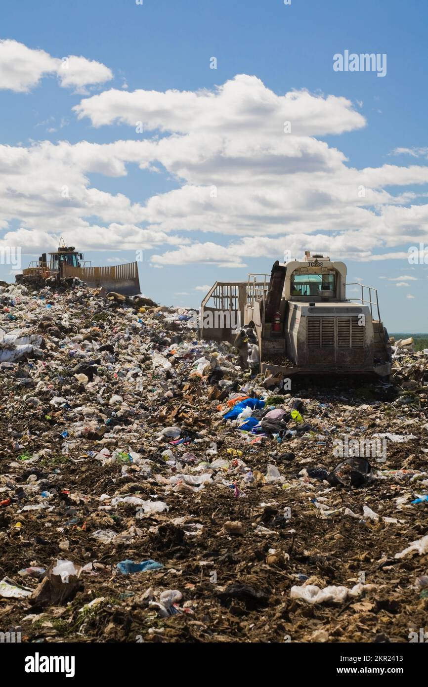 Landfill compactors spreading out and compacting discarded debris and