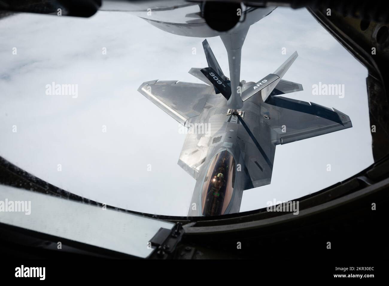 A U.S. Air Force F-22A Raptor assigned to the 3rd Wing, receives fuel from a KC-135 Stratotanker assigned to the 909th Air Refueling Squadron, over the Pacific Ocean, Nov. 23, 2022. The U.S.-Japan Alliance is the cornerstone of peace and security in the Indo-Pacific allowing for the forward basing of our most advanced military capabilities. (U.S. Air Force photo by Senior Airman Yosselin Campos) Stock Photo