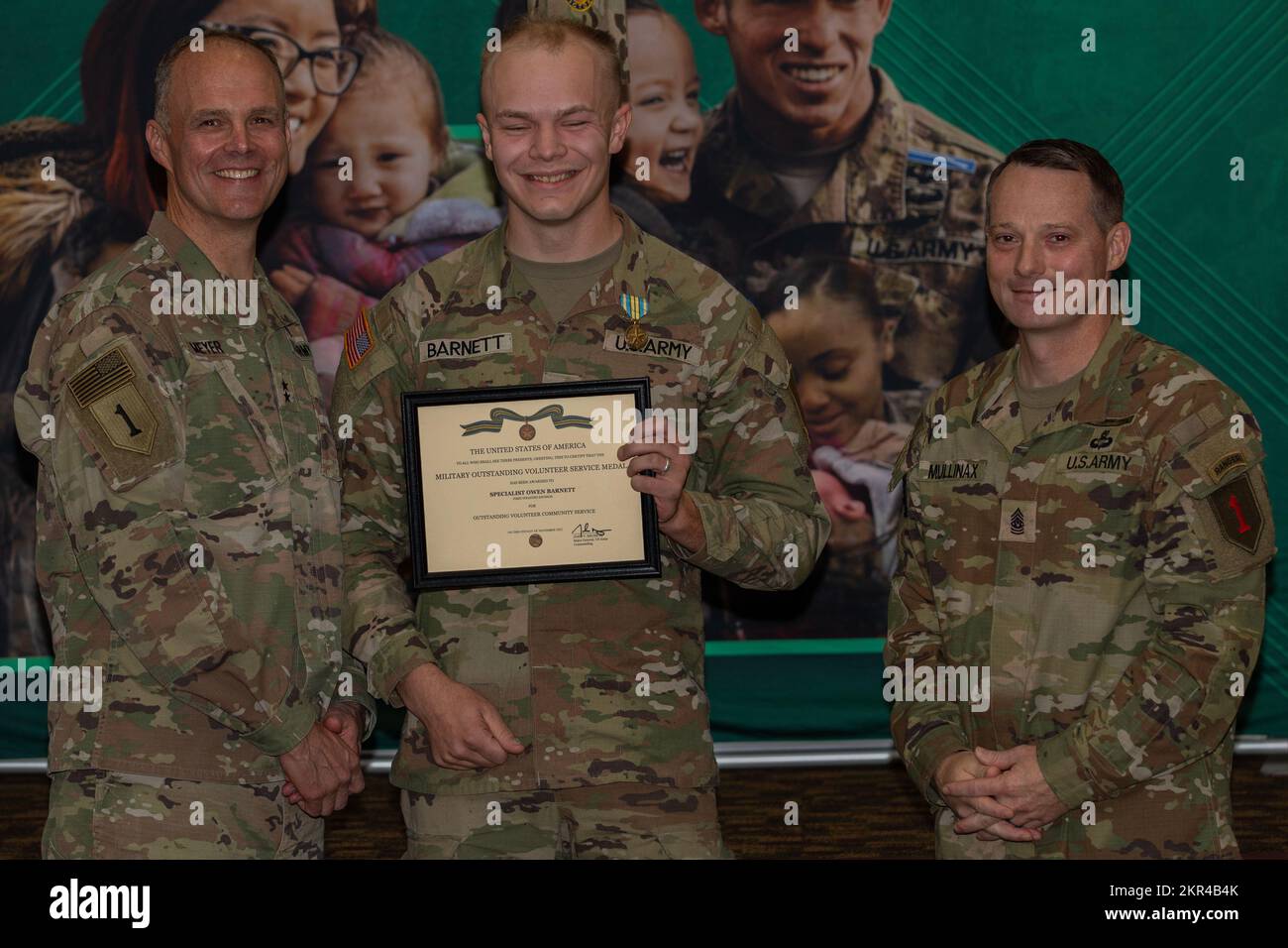 U.S. Army Spc. Owen Barnett (middle), receives a Military Outstanding Volunteer Service Medal from Maj. Gen. John Meyer III (left), commanding general of the 1st Infantry Division and Fort Riley, and Command Sgt. Maj. Christopher Mullinax (right), the command sergeant major of the 1st Inf. Div. and Fort Riley, Nov. 7, 2022, at Victory Hall in Fort Riley, Kansas. Barnett received the medal for his volunteer work with the Boy Scouts of America. Stock Photo