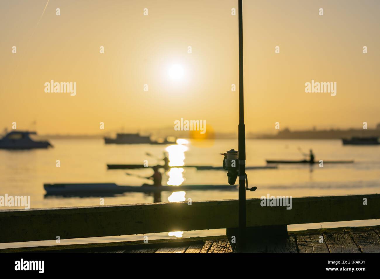 Fishing rod and reel standing on jetty at sunrise hoping for a catch at ...