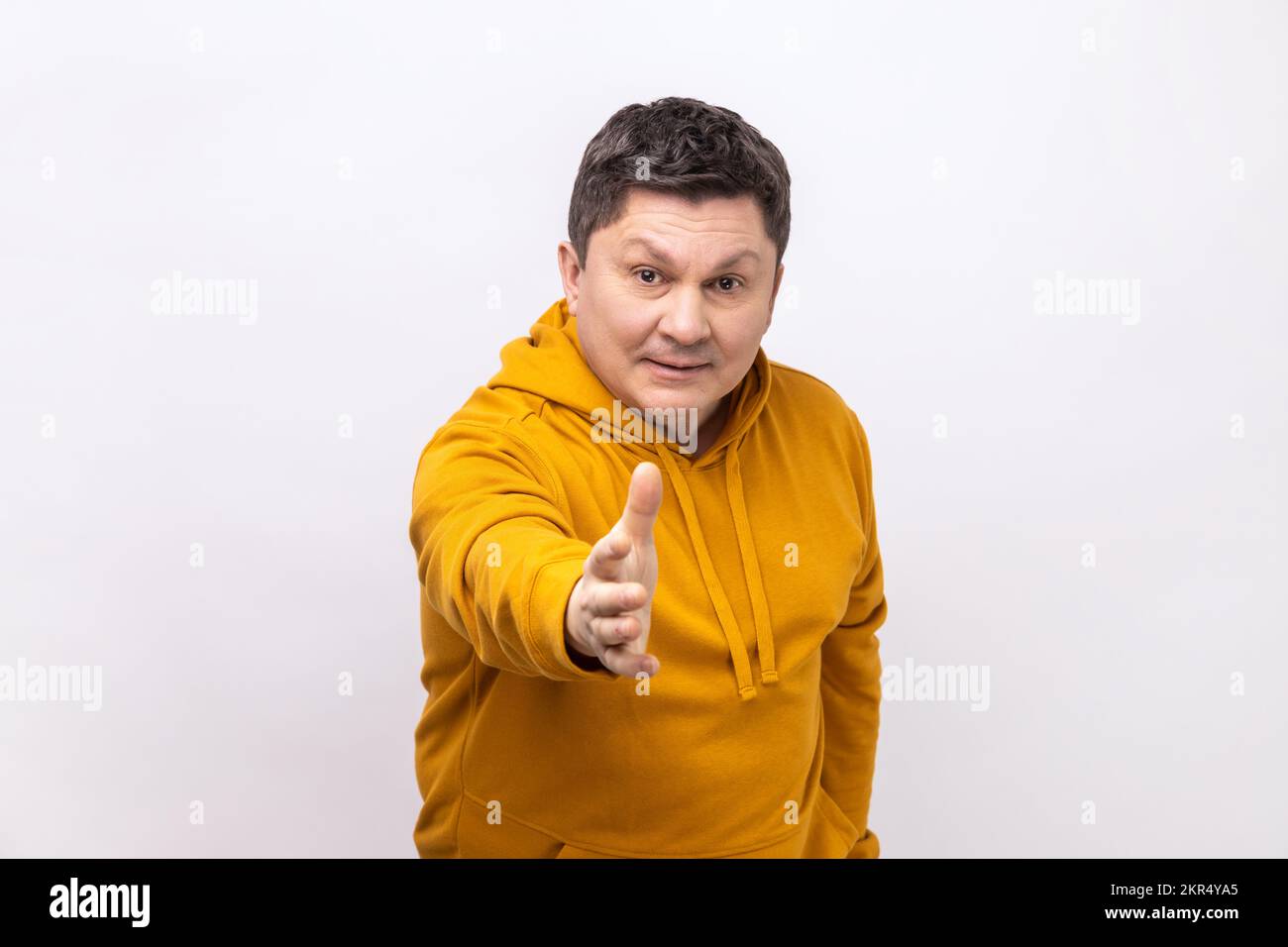 Portrait of middle aged man standing with outstretched hand, offering