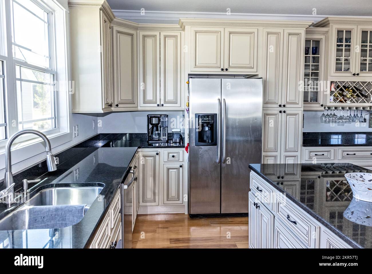 A cream colored new construction kitchen with black granite countertops ...