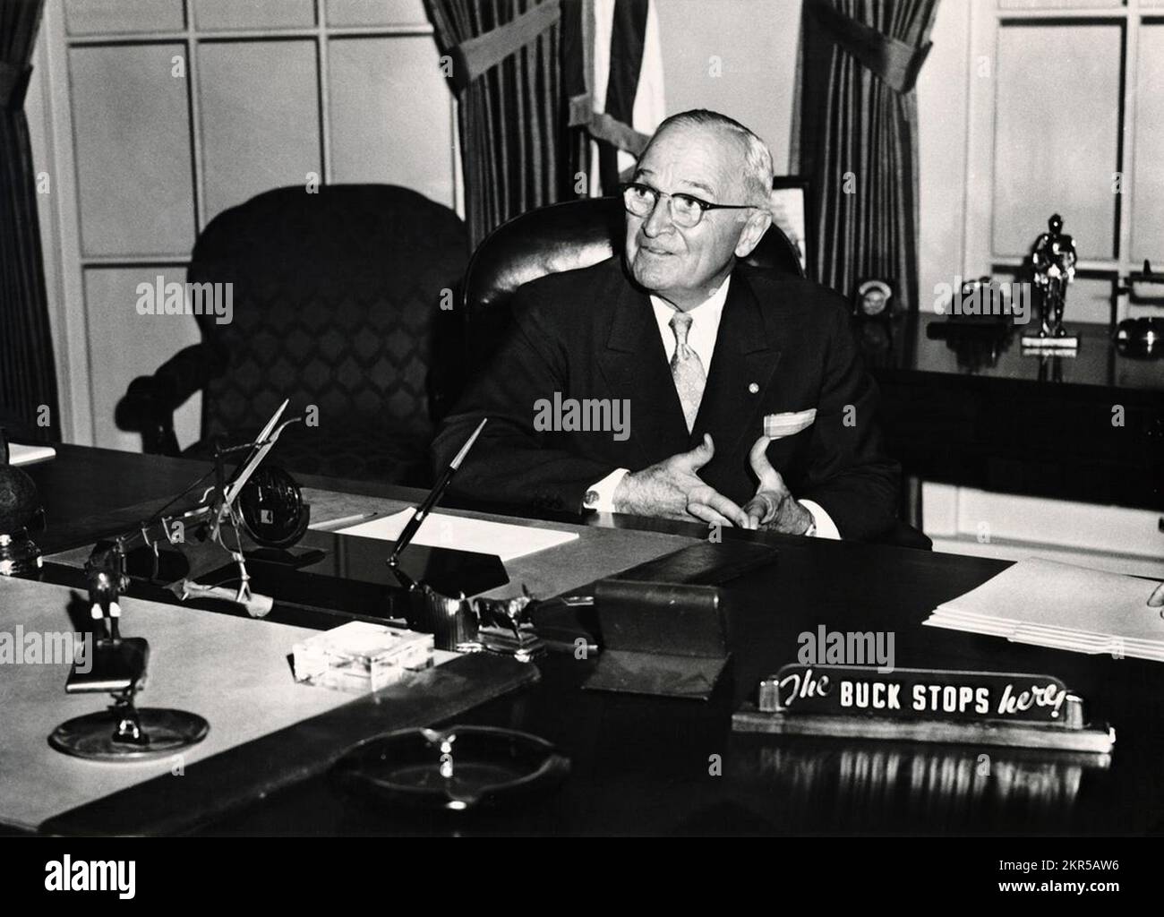 Former President Harry Truman with 'The Buck Stops Here' sign on a recreation of his Oval Office desk Stock Photo