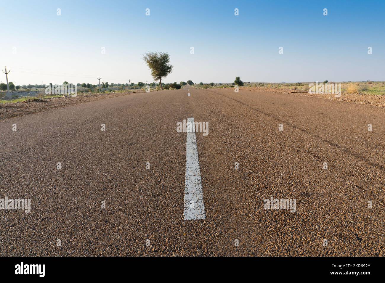 Morning in desert with empty high road or national high way passing through the desert. Distant horizon, Hot summer at Thar desert, Rajasthan, India. Stock Photo