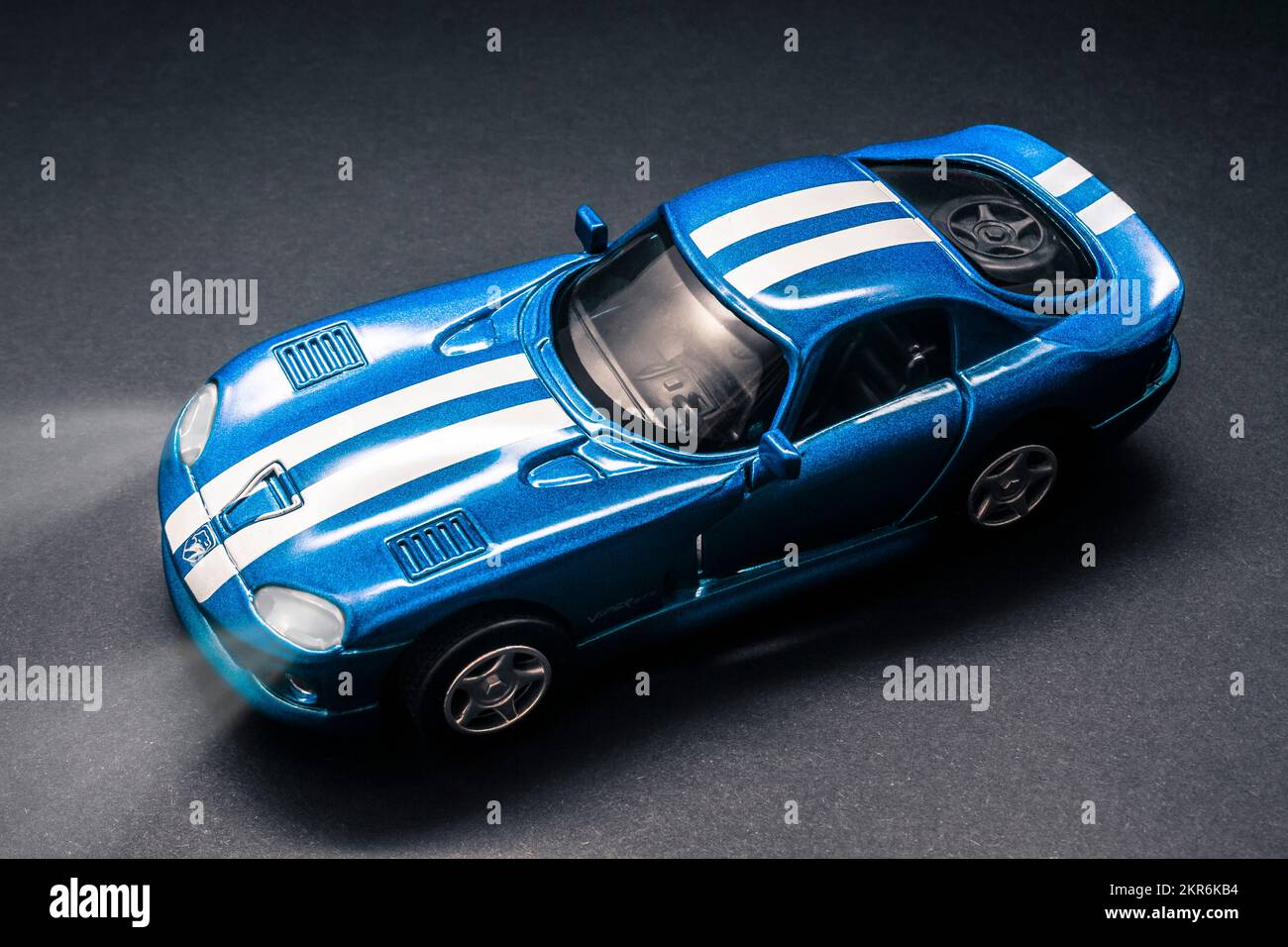 Model Dodge Viper GTS captured in midnight blue with headlights beaming and race stripe styling. Night Drives Stock Photo