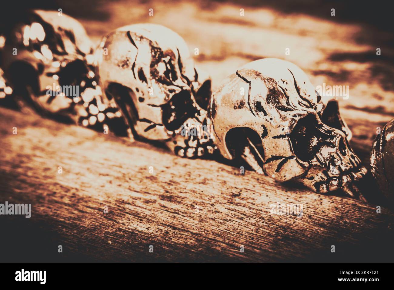 Retro toned artwork on a lineup of spooky skeleton craniums in halloween style Stock Photo