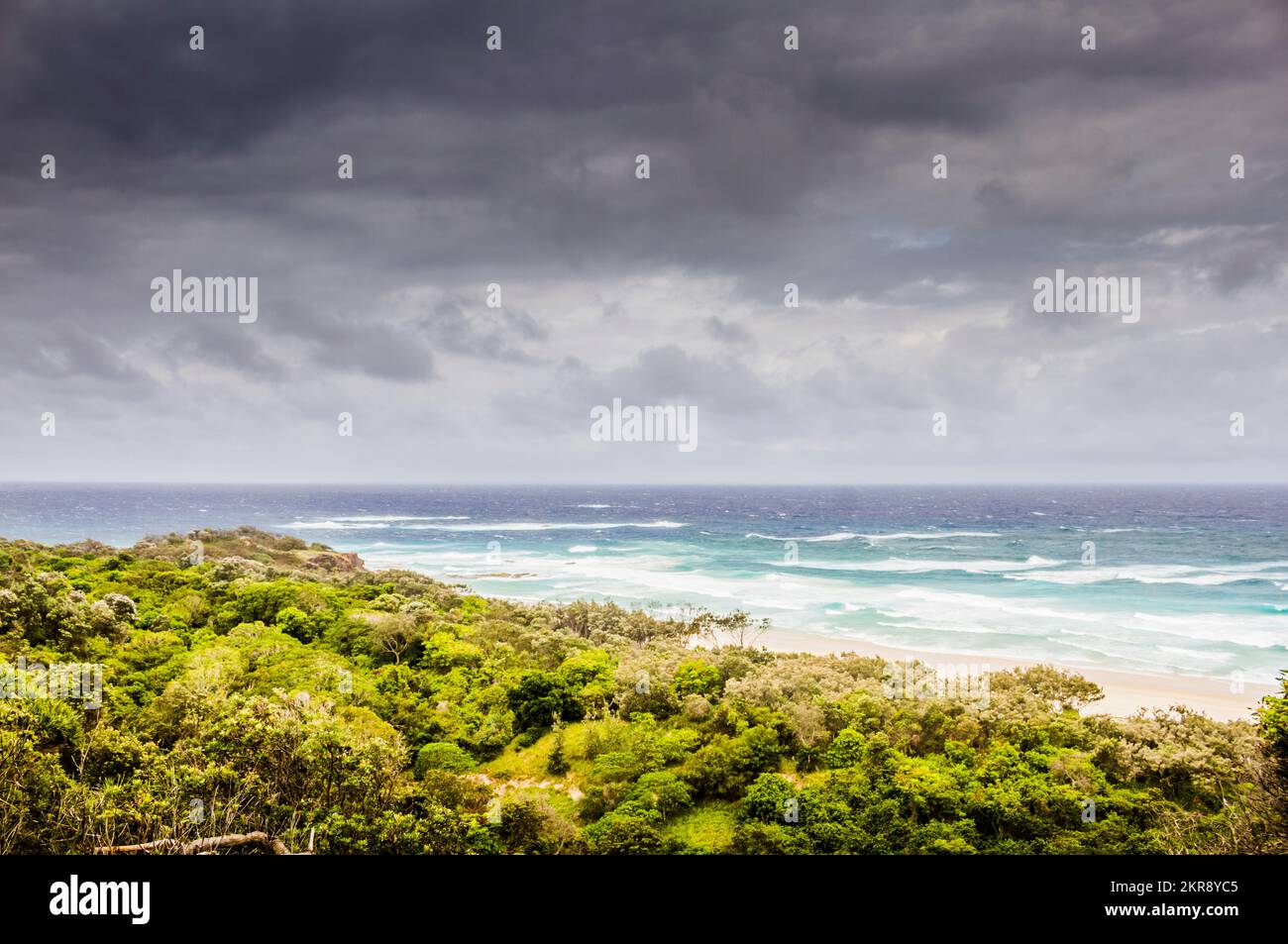 Scenic summer surf scene with storm clouds gathering before dynamic country greens. Captured: Frenchman's Beach, Point Lookout, North Stradbroke Islan Stock Photo