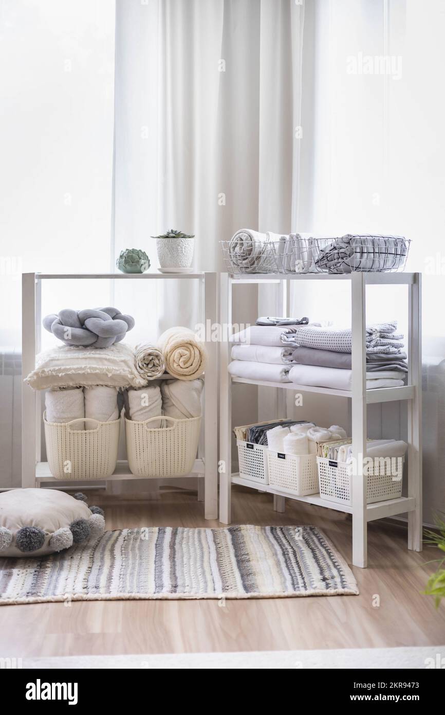 Wardrobe in the bedroom with neatly folded linen vertical storage and stacks. Stock Photo