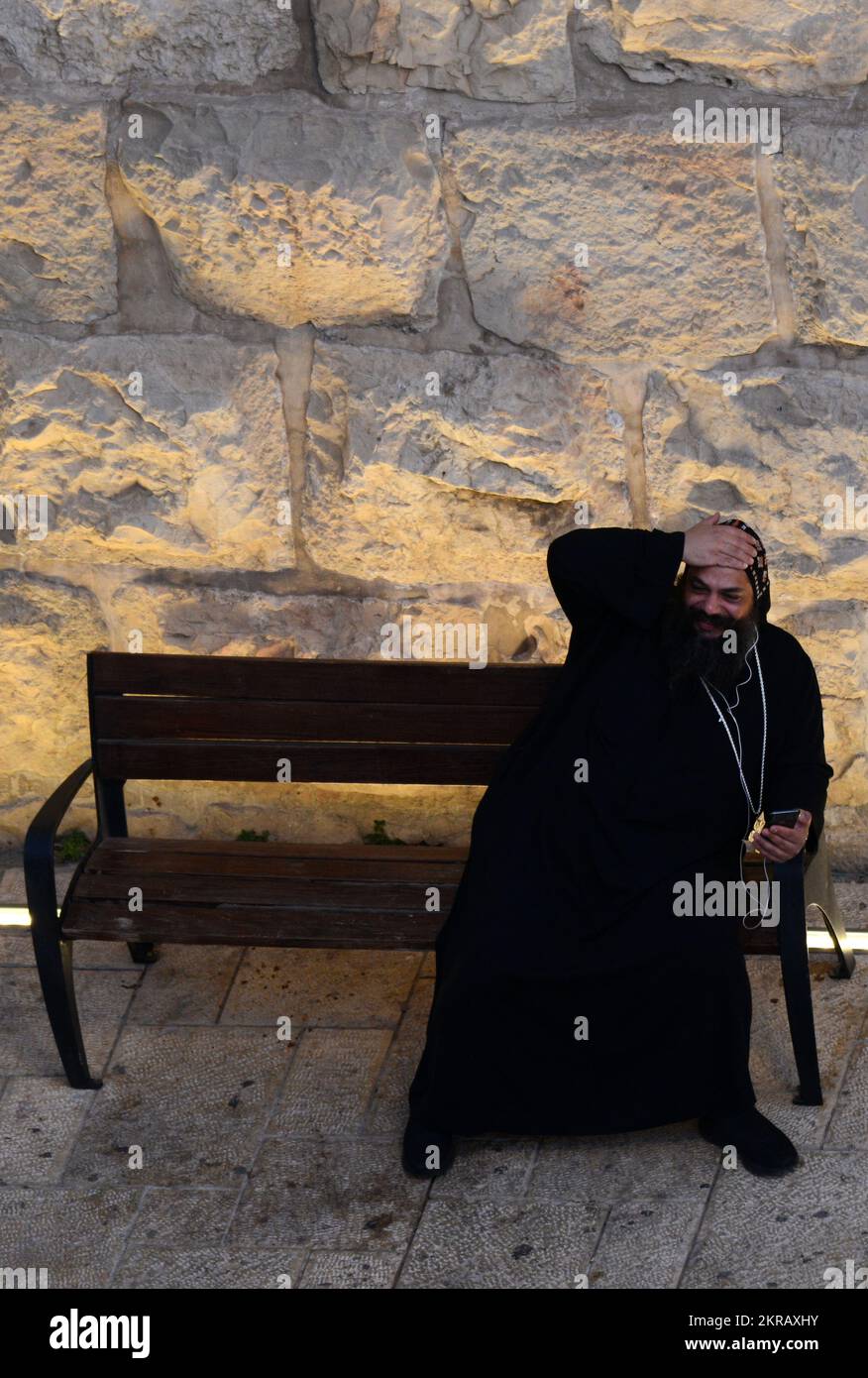 A Coptic priest using his smartphone by the New Gate, Old City of Jerusalem, Israel. Stock Photo