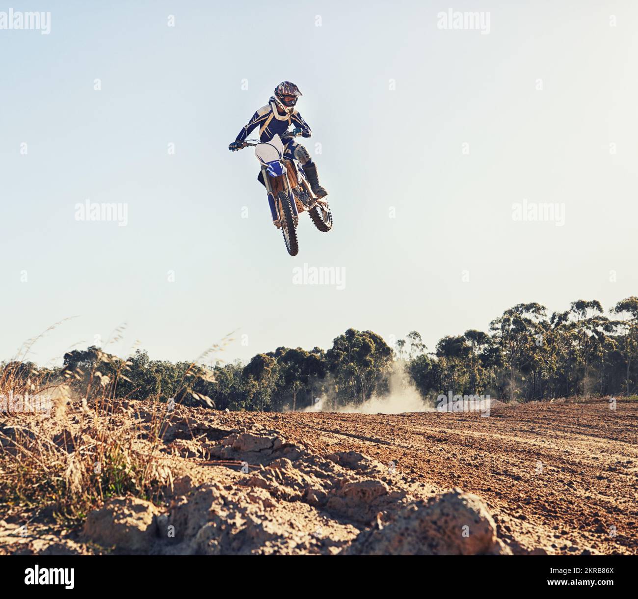 Hitting the jump at full throttle. a motocross rider coming over a jump during a race. Stock Photo