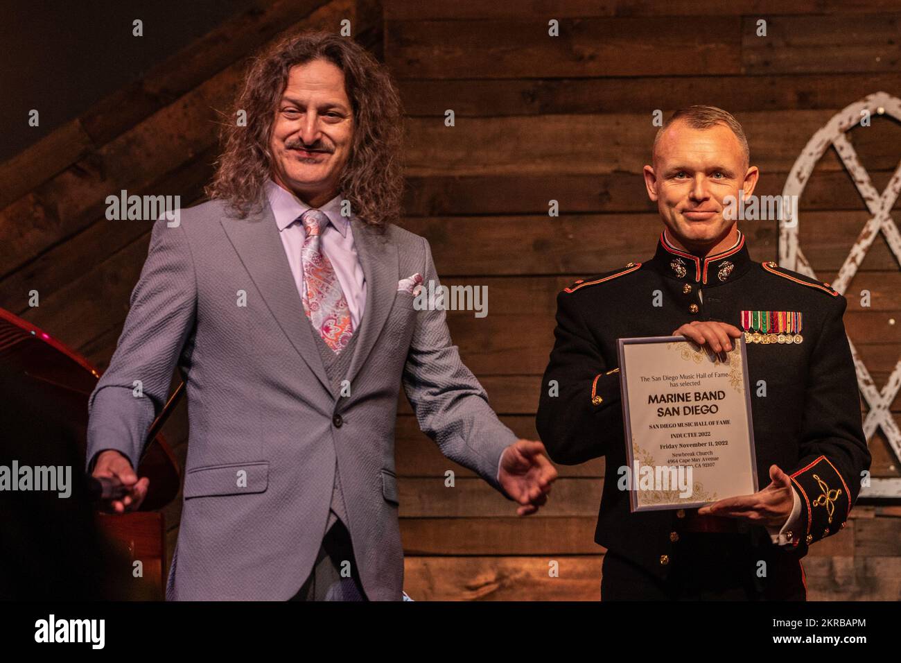 U.S. Marine Corps Chief Warrant Officer 2 Randel Metzinger with Marine Band San Diego, Service Company, Headquarters and Service Battalion, is presented a certificate by Jefferson Jay, the San Diego Music Hall of Fame president, during the 4th annual San Diego Music Hall of Fame Induction Ceremony in San Diego, California, Nov. 11, 2022. Marine Band San Diego was inducted into this year's San Diego Music Hall of Fame based off of its continual public appearances throughout the years to provide musical support for military and civic ceremonies in the San Diego community. Stock Photo