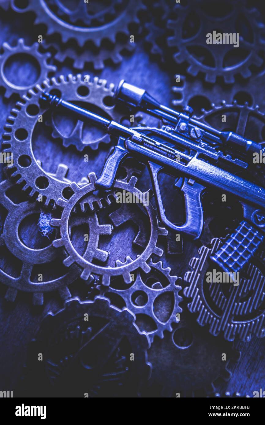 Combative artwork on a black ops Steyr firearm laying on the gears of a night watch Stock Photo