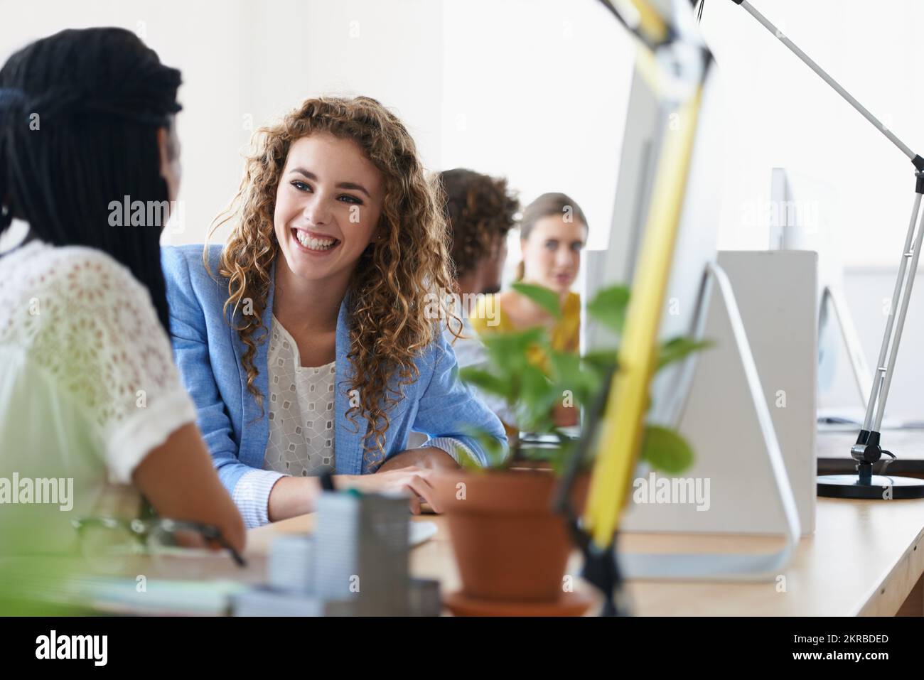 Sharing their creativity. young designers talking while working on their computers. Stock Photo