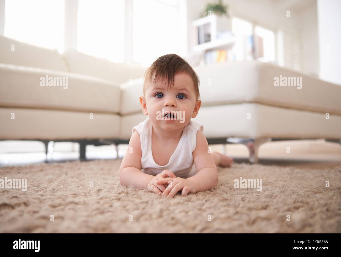 Baby relaxation. a baby lying on his stomach on the carpet Stock Photo ...