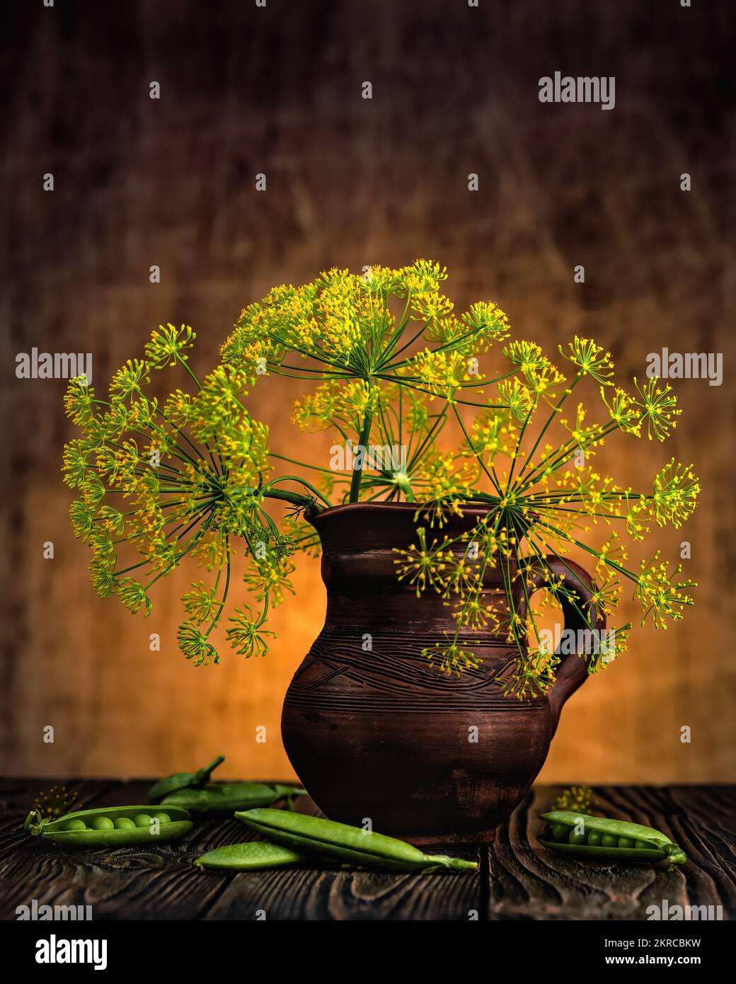 Clay jug on a dark background with dill branches and peas Stock Photo