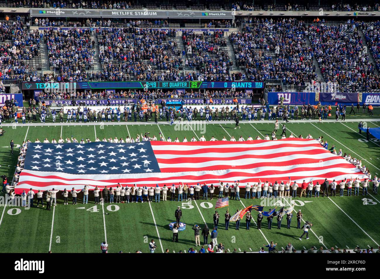 An American flag is unfurled during the New York Giants pregame ceremonies at Metlife Stadium, Nov. 13, 2022. Sailors assigned to the San Antonio-class amphibious transport dock ship USS Arlington (LPD 24) and II Marine Expeditionary Force (MEF) Marines are participating in events in and around New York City during the week-long Veterans Day New York celebration to honor the service and sacrifice of the nation’s veterans. Stock Photo