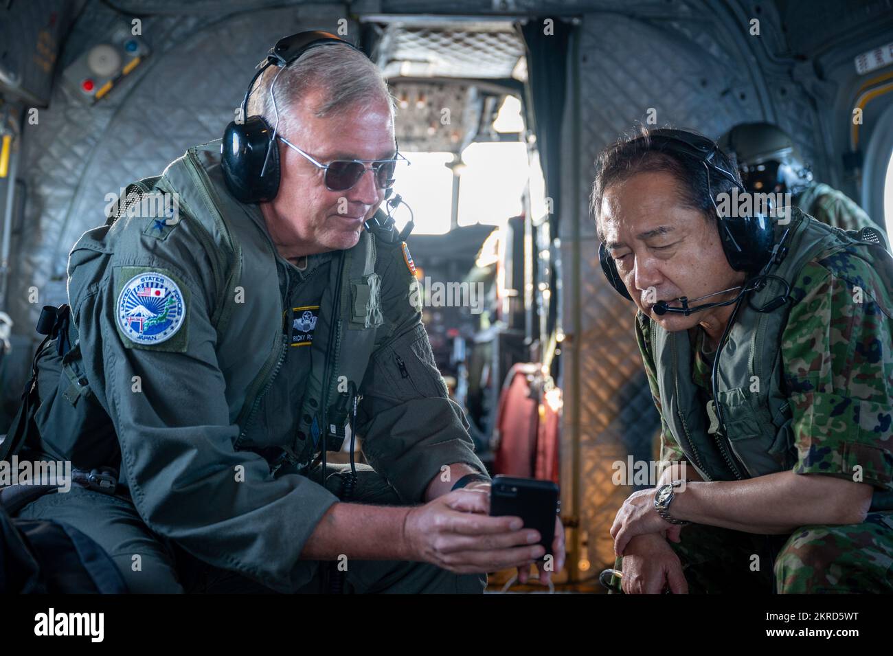 Lt. Gen. Ricky Rupp, commander of U.S. Forces Japan and Fifth Air Force, shares a video of recent U.S. military exercises with General Yamazaki Koji, chief of staff of the Japan Joint Staff, aboard a Japan Self-Defense Forces CH-47JA helicopter on their way to the Japanese destroyer JS Izumo as part of Keen Sword 23. Keen Sword is a biennial, joint and bilateral field-training exercise involving U.S. military and Japan Self-Defense Force personnel, designed to increase readiness and interoperability while strengthening the ironclad Japan-U.S. alliance. (Photo by Air Force Maj. Thomas Barger) Stock Photo