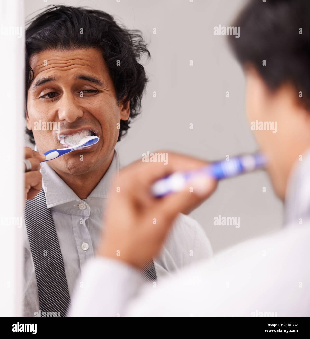 Getting ready for work. A young businessman looking exhausted while