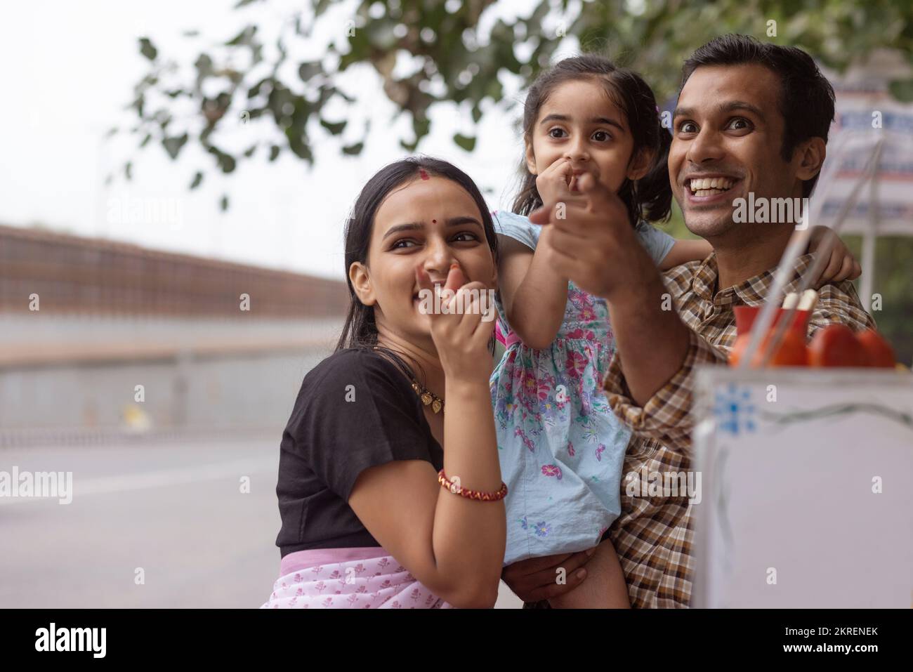 Portrait of happy family standing near street shop Stock Photo