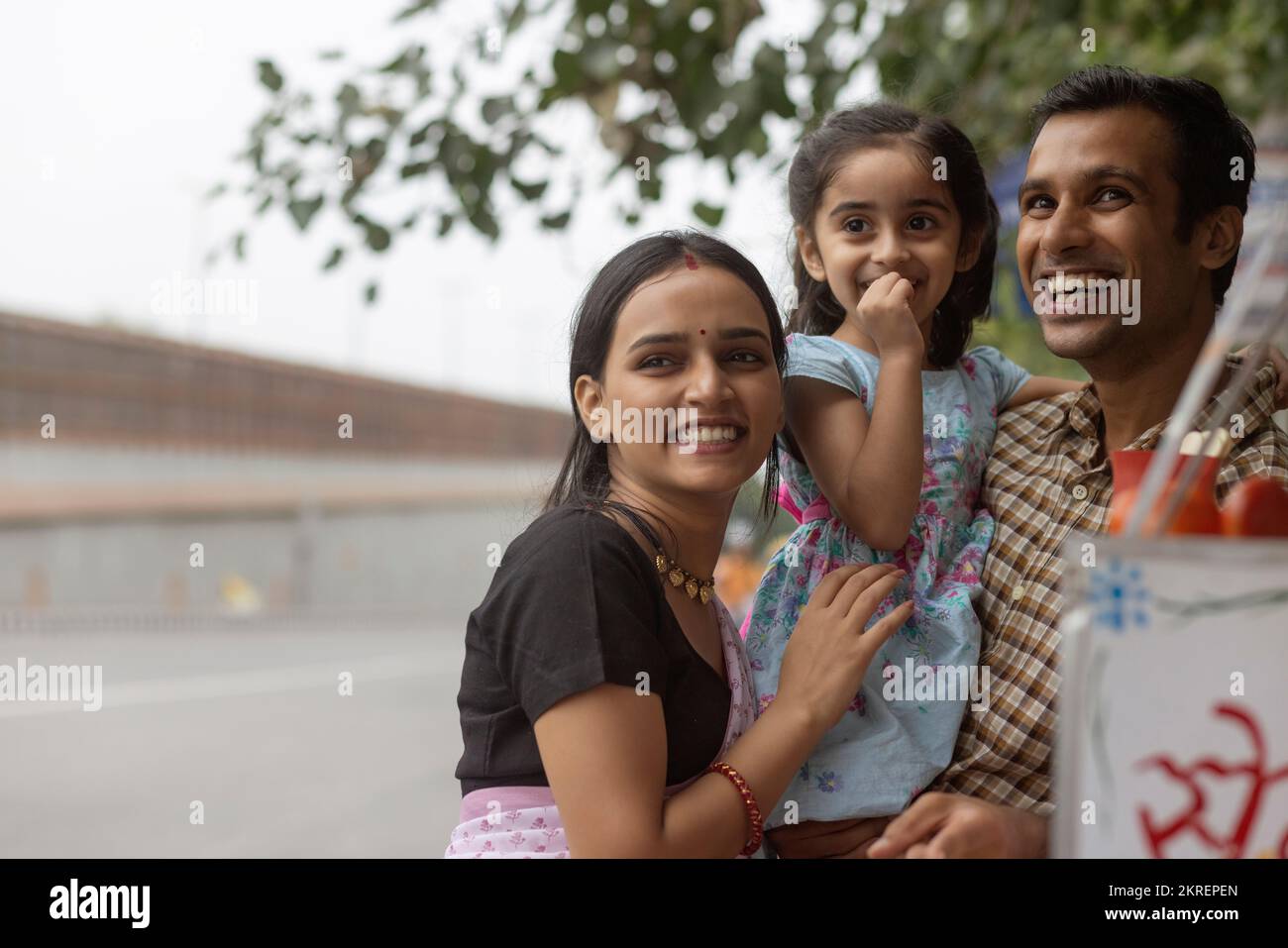 Portrait of happy family standing near street shop Stock Photo