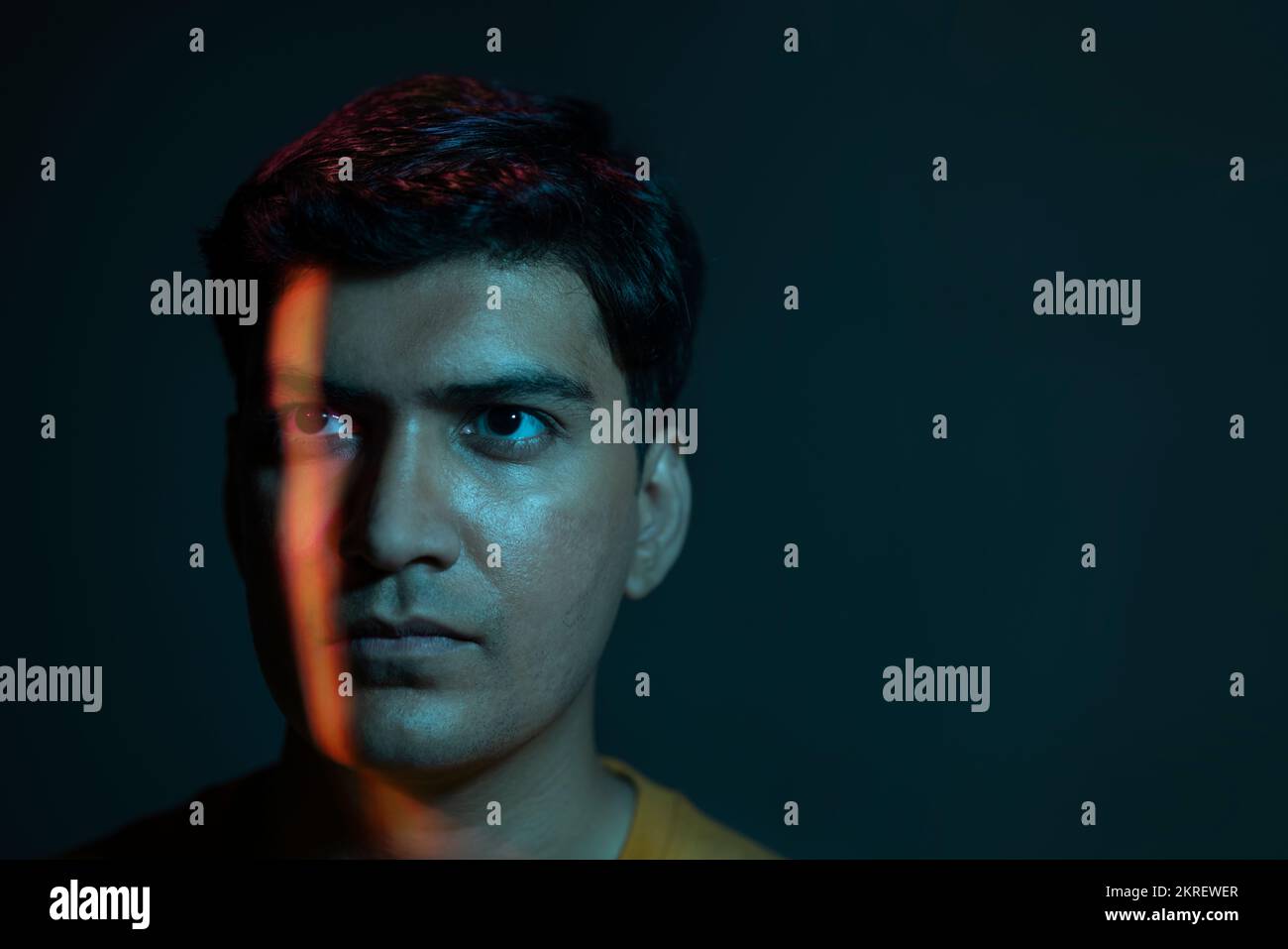 Portrait of man lit by neon colored lights on face Stock Photo