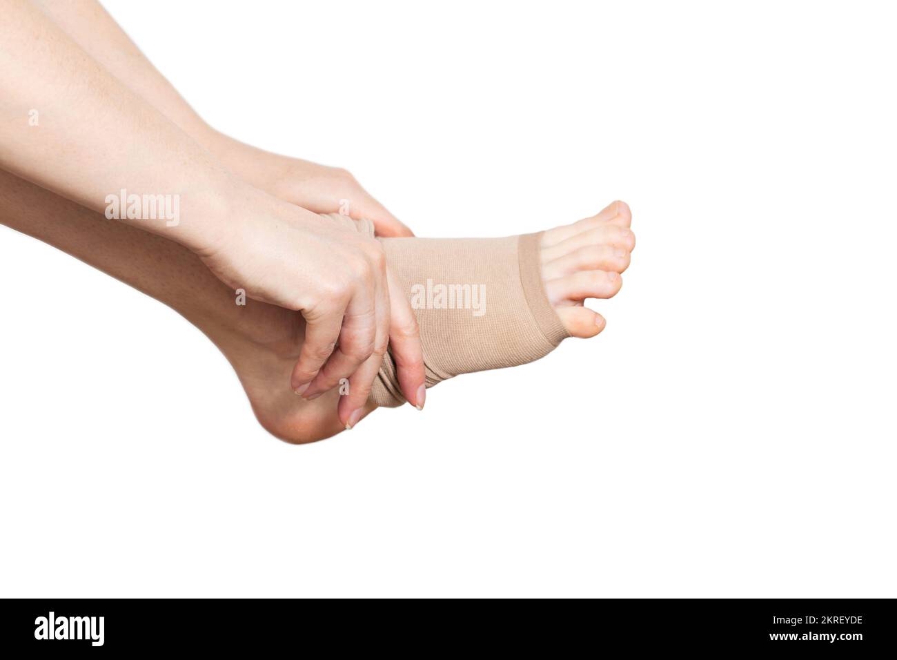 A woman puts on compression stockings for legs with varicose veins