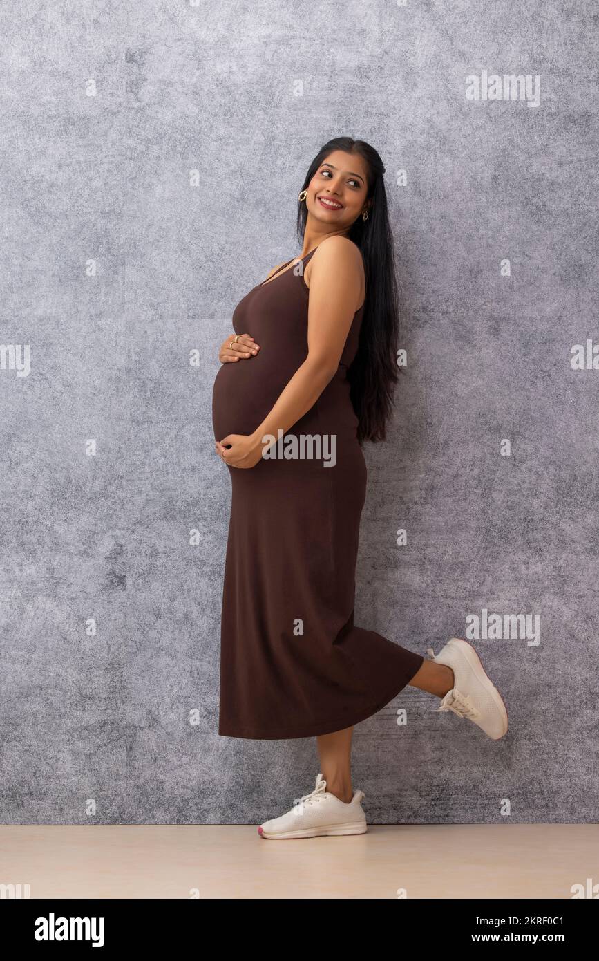 Woman standing hands on stomach hi-res stock photography and images - Alamy