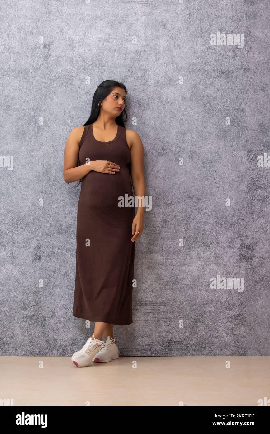 Woman standing by wall hi-res stock photography and images - Alamy