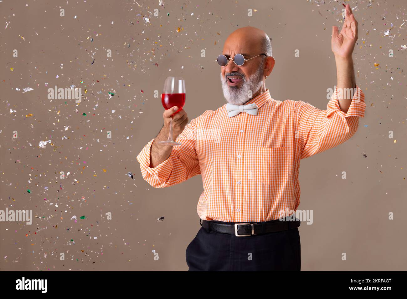 Senior man cheering with a glass of red wine Stock Photo