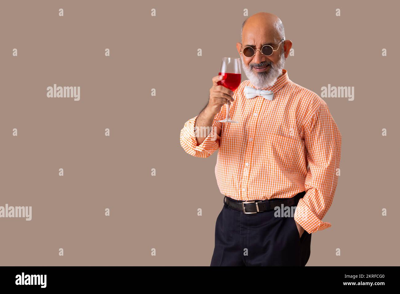 Senior man cheering with a glass of red wine Stock Photo