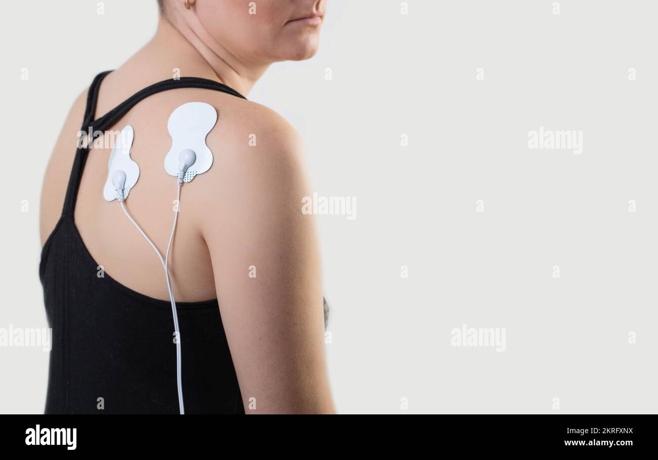 Acupuncture electronic massager on the back of a girl to relax muscles
