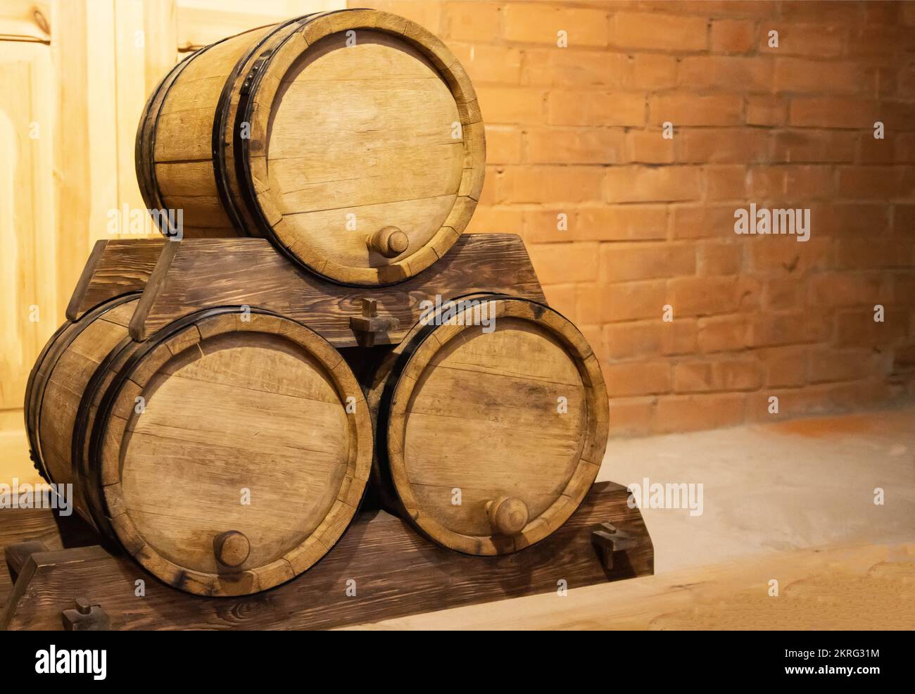 Three wooden barrels of gunpowder against a brick wall. Old antique