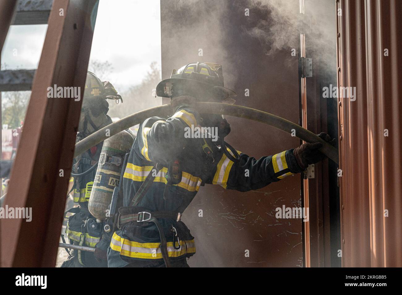 JOINT BASE LANGLEY-EUSTIS, Va. – Ray Flora, Hampton Division of Fire and Rescue medic firefighter, enters a building with a “Class A” fire during a rapid intervention team work exercise in the burn building at Joint Base Langley-Eustis, Virginia, Nov. 17, 2022. “Class A” fires indicate the source of the combustion to be from organic origins and contain carbon, in this case wood acted as the source of the combustion. Stock Photo