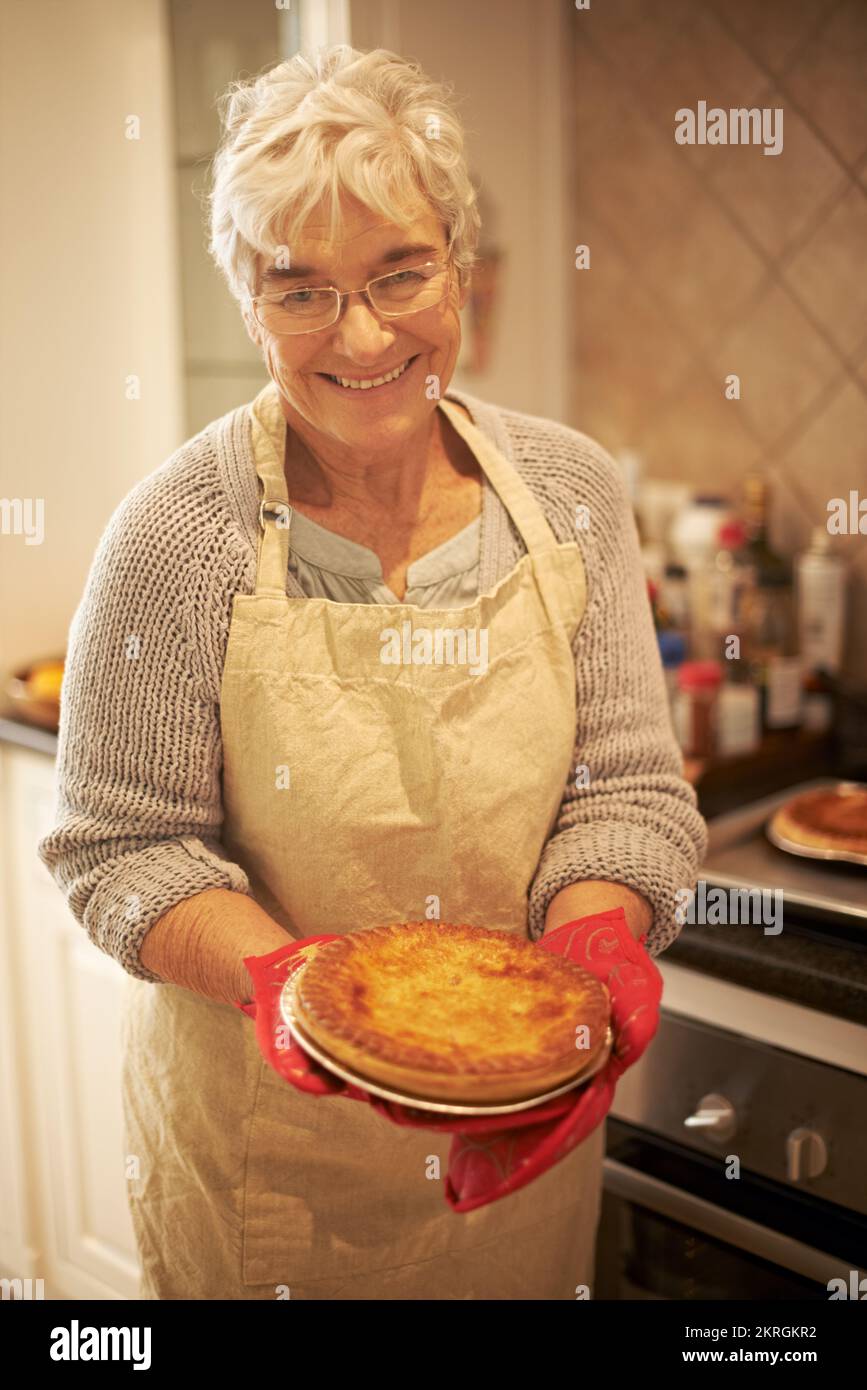 My own recipe. An elderly lady holding a pie that shes just baked. Stock Photo