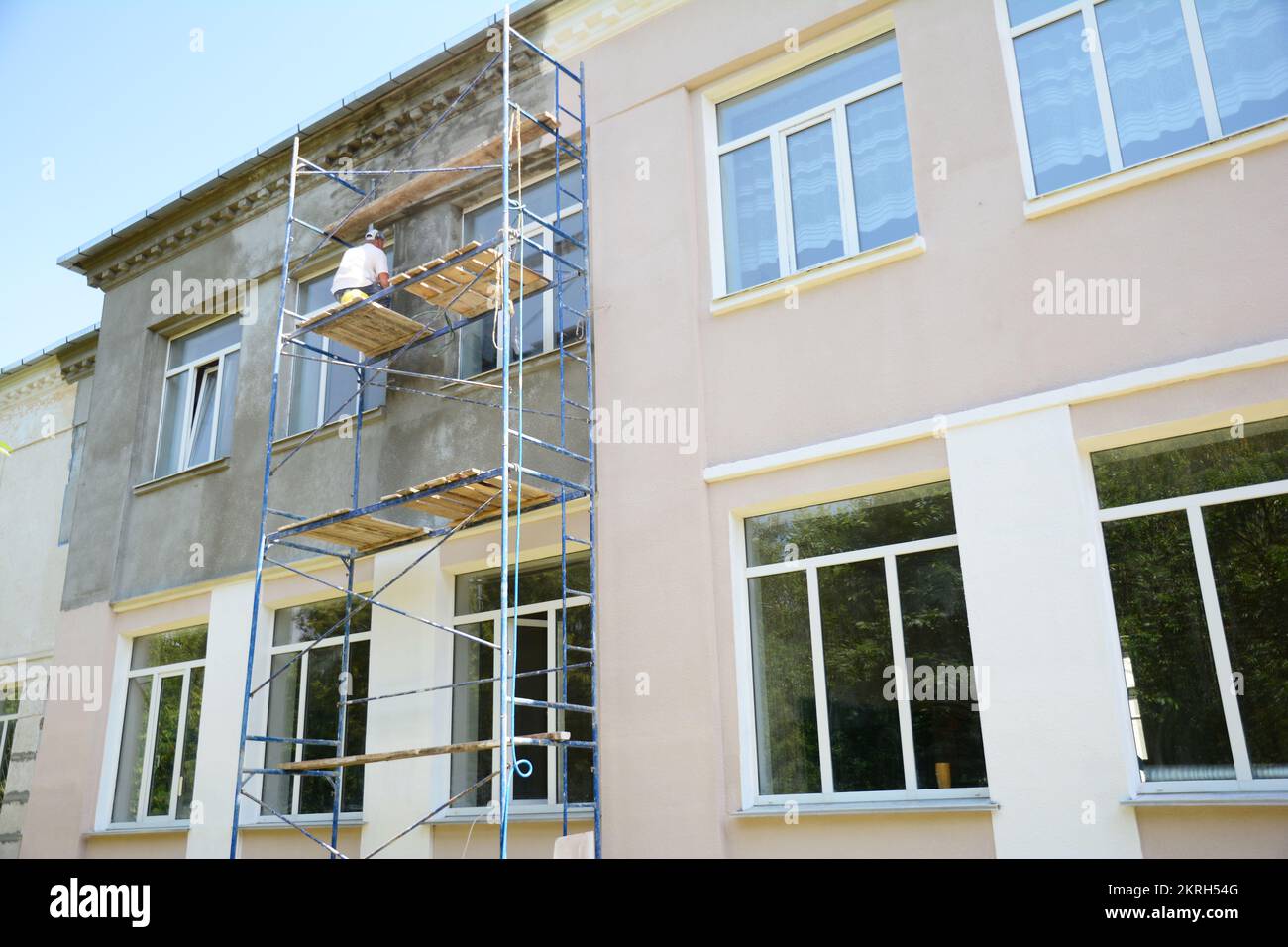 Builder contractor plastering external walls before painting outside