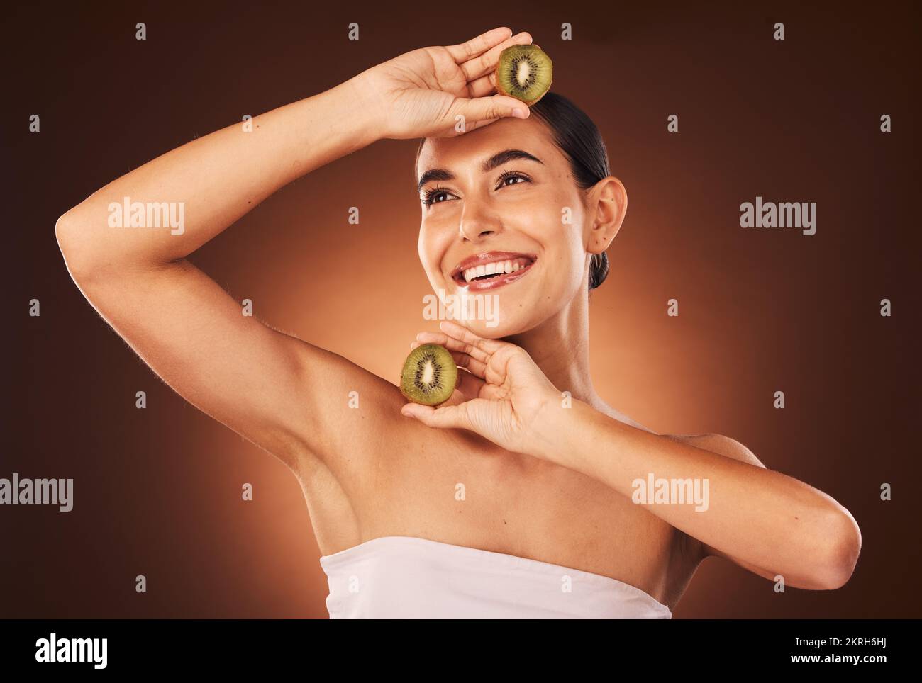 Beauty, skincare and kiwi fruit for health and wellness on studio background for dermatology treatment for a glow and happiness. Face of aesthetic Stock Photo