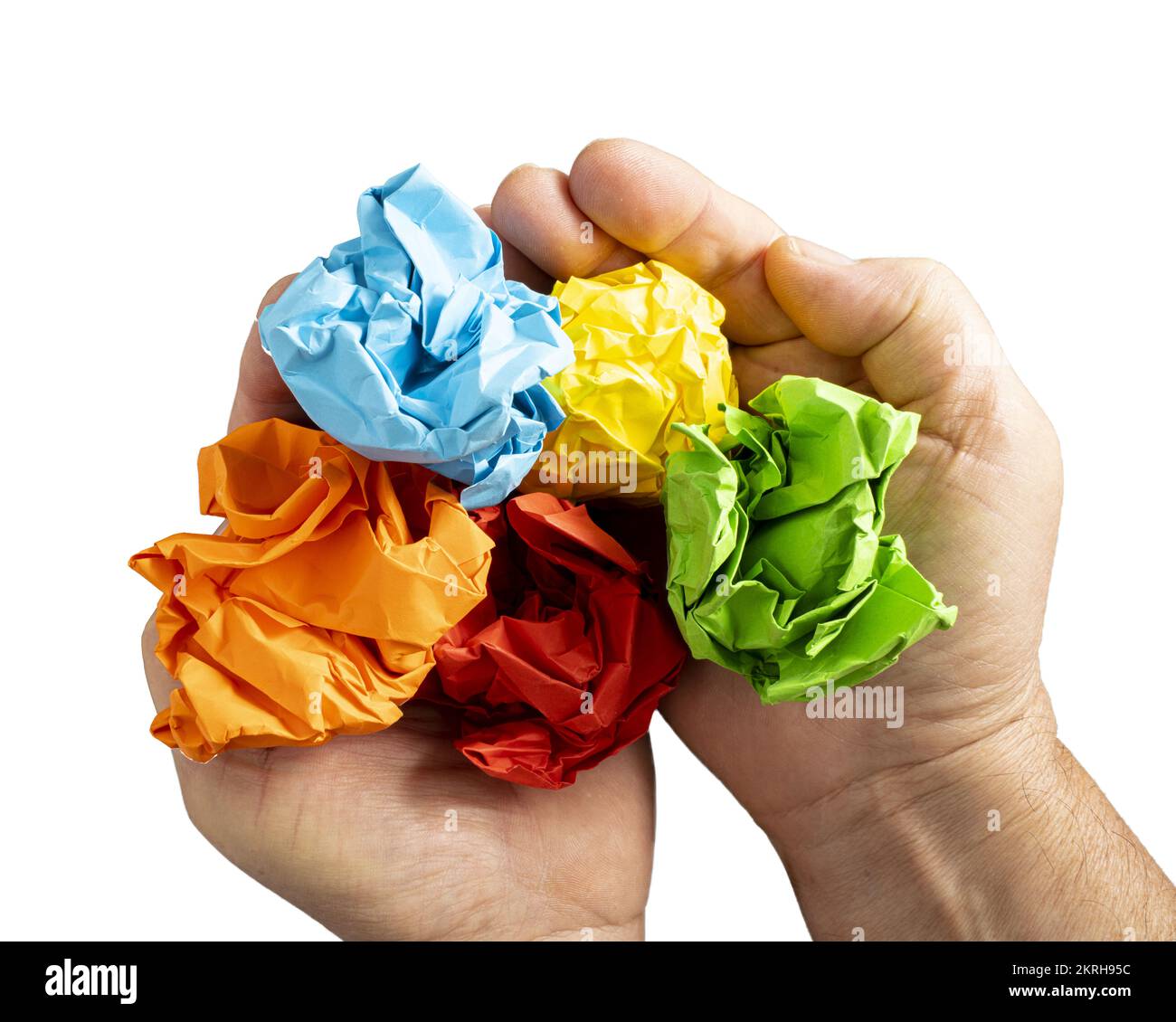 a few sheets of crumpled colored paper in the hands Stock Photo