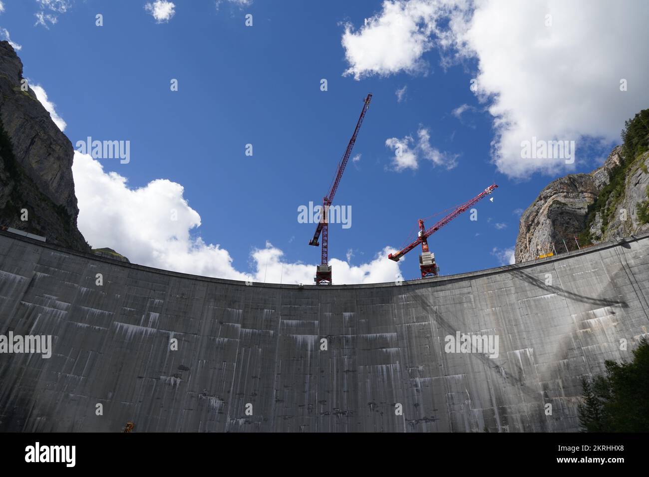 Huge grey wall of Gigerwald Dam which stands between rock faces of the Ringelspitz massif. Stock Photo